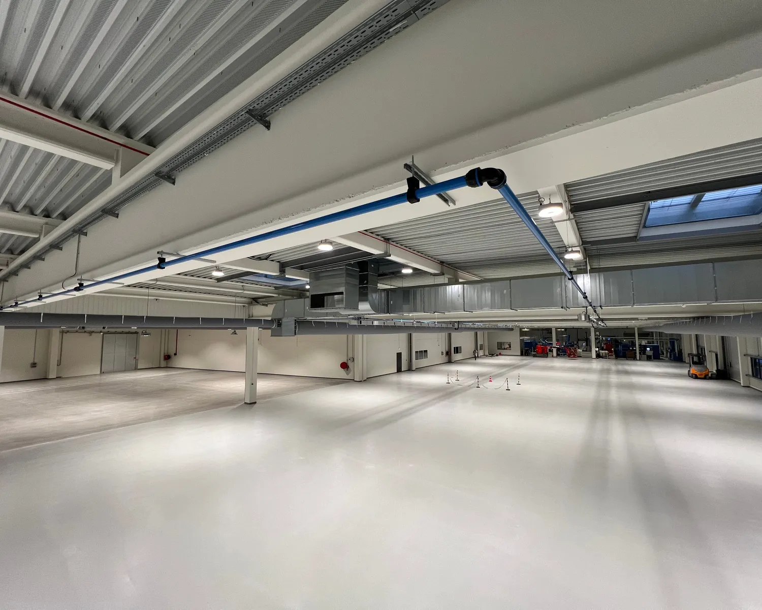 Réseau d'air comprimé en tuyauterie aluminium installé en hauteur par MECAB dans une extension d'usine